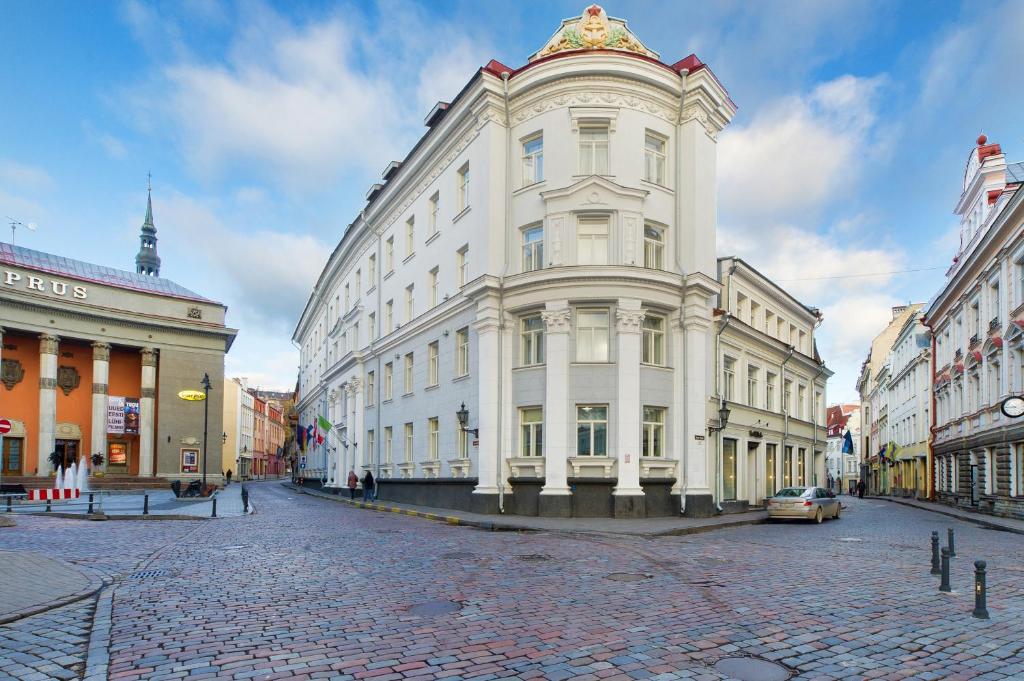 a large white building on a cobblestone street at My City Hotel in Tallinn