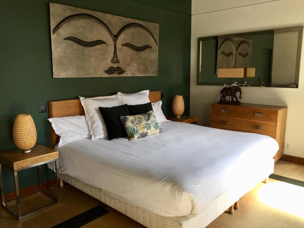 um quarto com uma grande cama branca e paredes verdes em Villa La Clarté em Cavalaire-sur-Mer