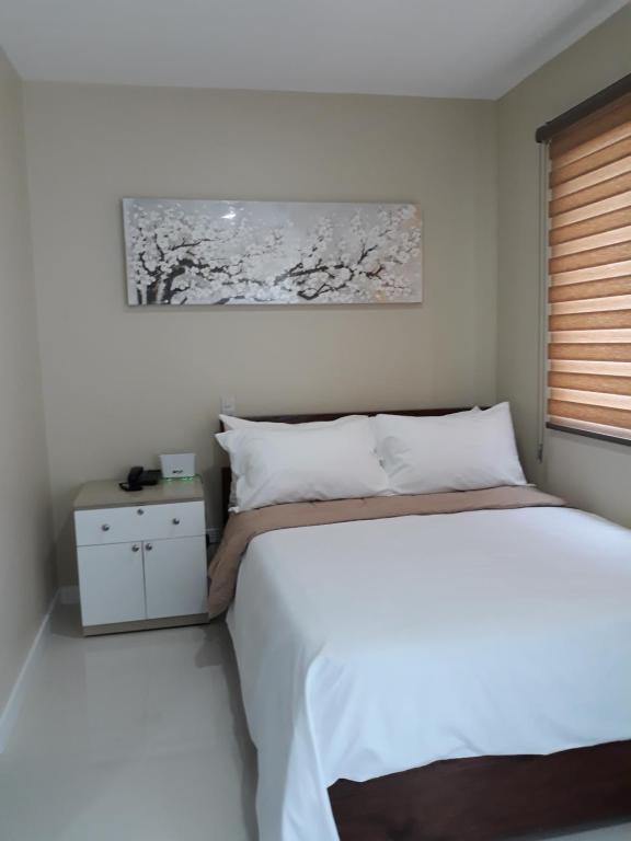 a bedroom with a white bed and a window at YulZ 516 at Cityscape in Bacolod