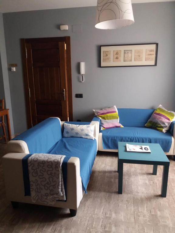 Sala de estar con 2 sofás y mesa en Apartamentos Turísticos EL Duende de Carricuende, en Puente-Almuhey