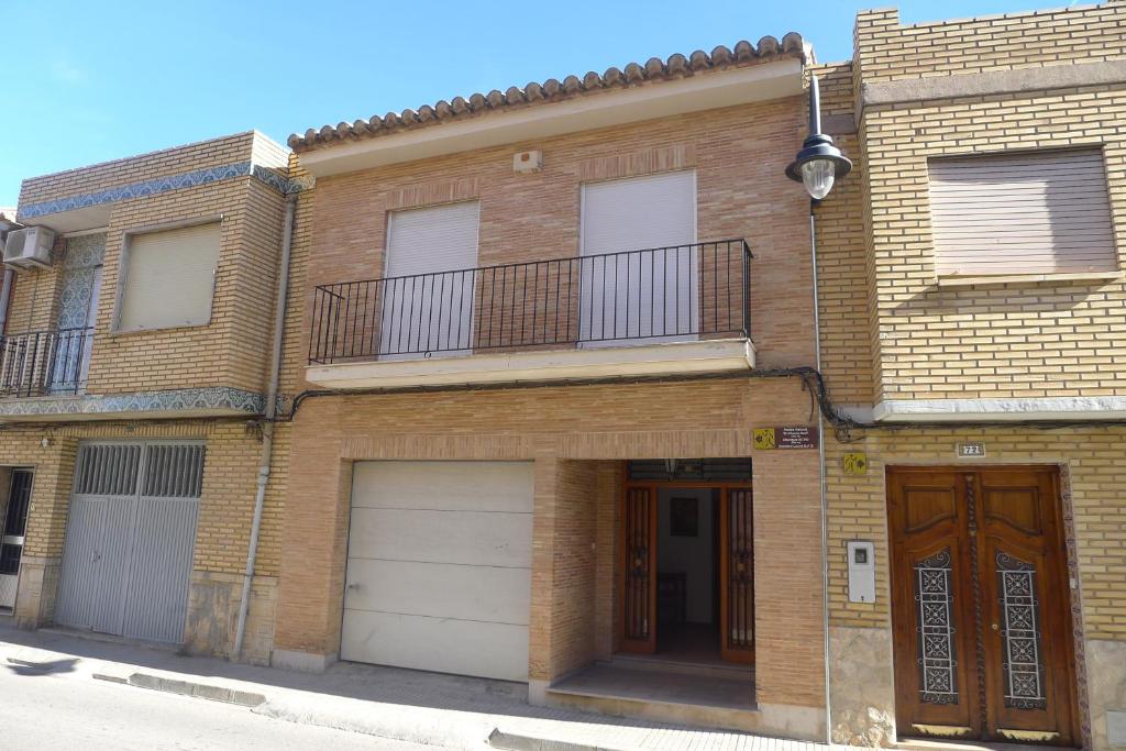a brick building with two garage doors and a balcony at Casa Esperanza in Alborache