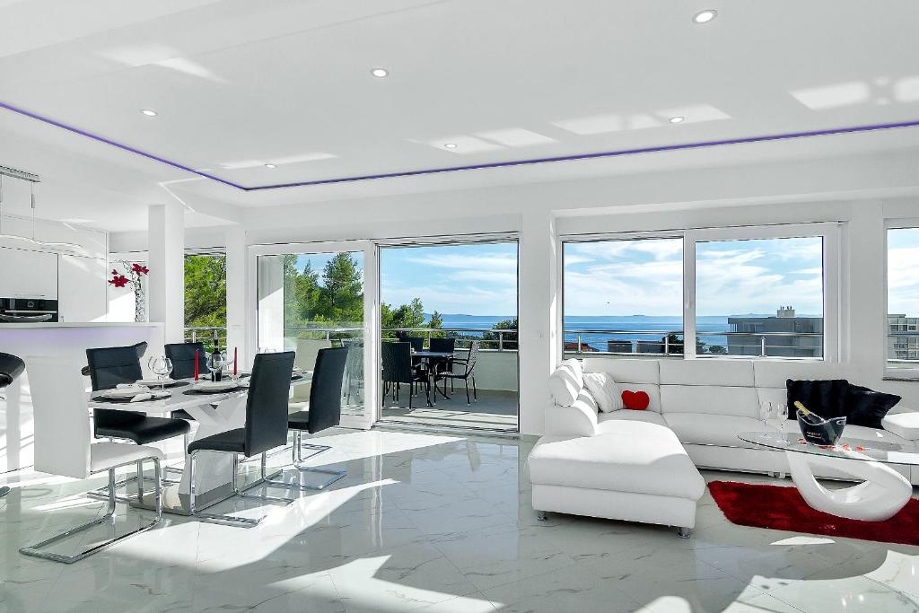 ein weißes Wohnzimmer mit einem weißen Sofa und Stühlen in der Unterkunft Penthouse Lush Makarska in Makarska