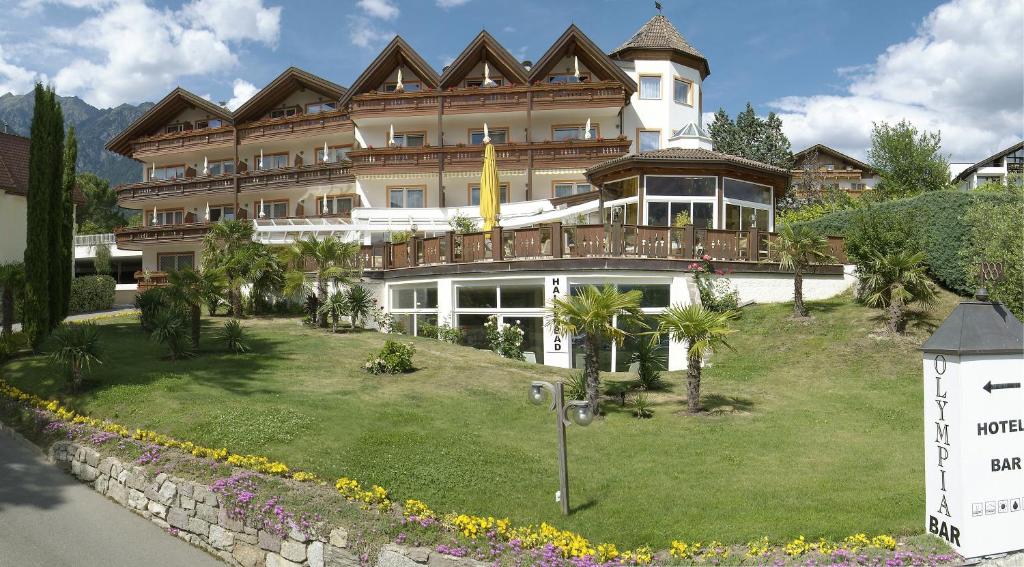 ein großes Gebäude mit Rasen davor in der Unterkunft Frühstücks-Hotel Olympia in Dorf Tirol