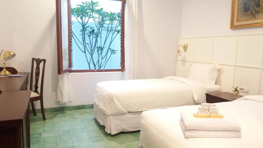 a hotel room with two beds and a window at Griya Asih in Yogyakarta