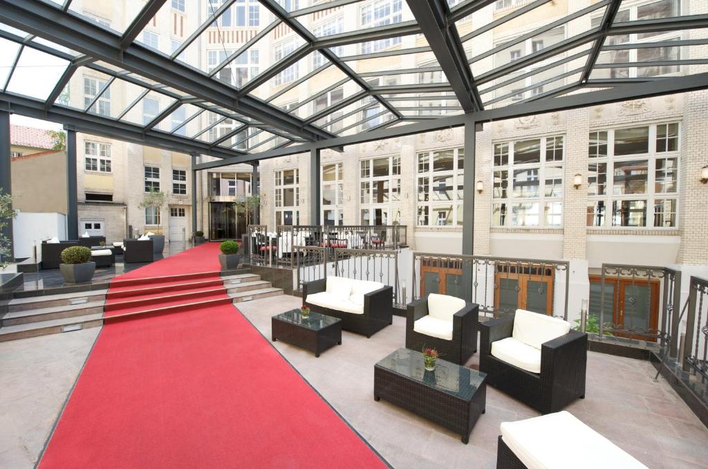 - un grand bâtiment doté d'une moquette rouge et d'un plafond en verre dans l'établissement Wyndham Garden Berlin Mitte, à Berlin