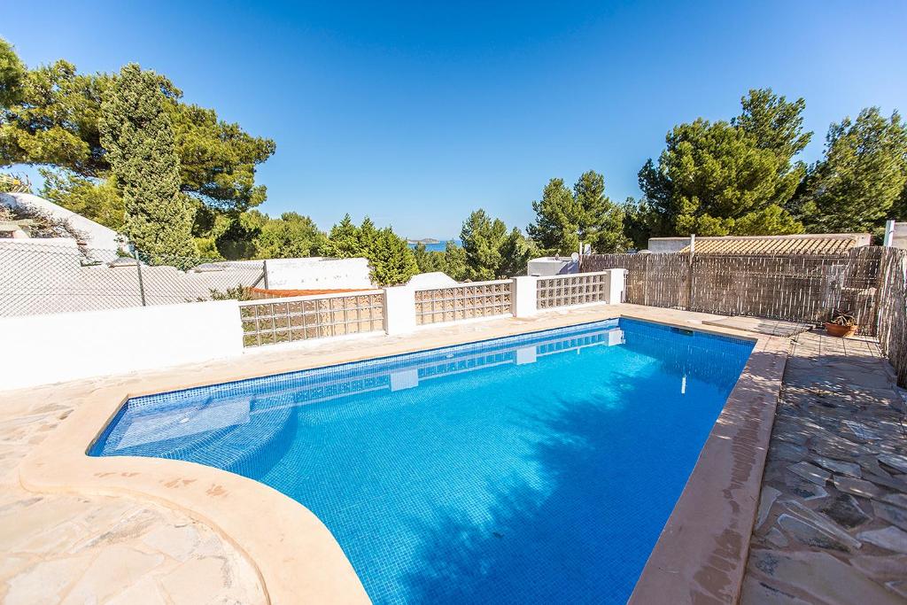 een groot blauw zwembad in een tuin bij Villa en Cala Vadella Familias y Parejas in San Jose de sa Talaia