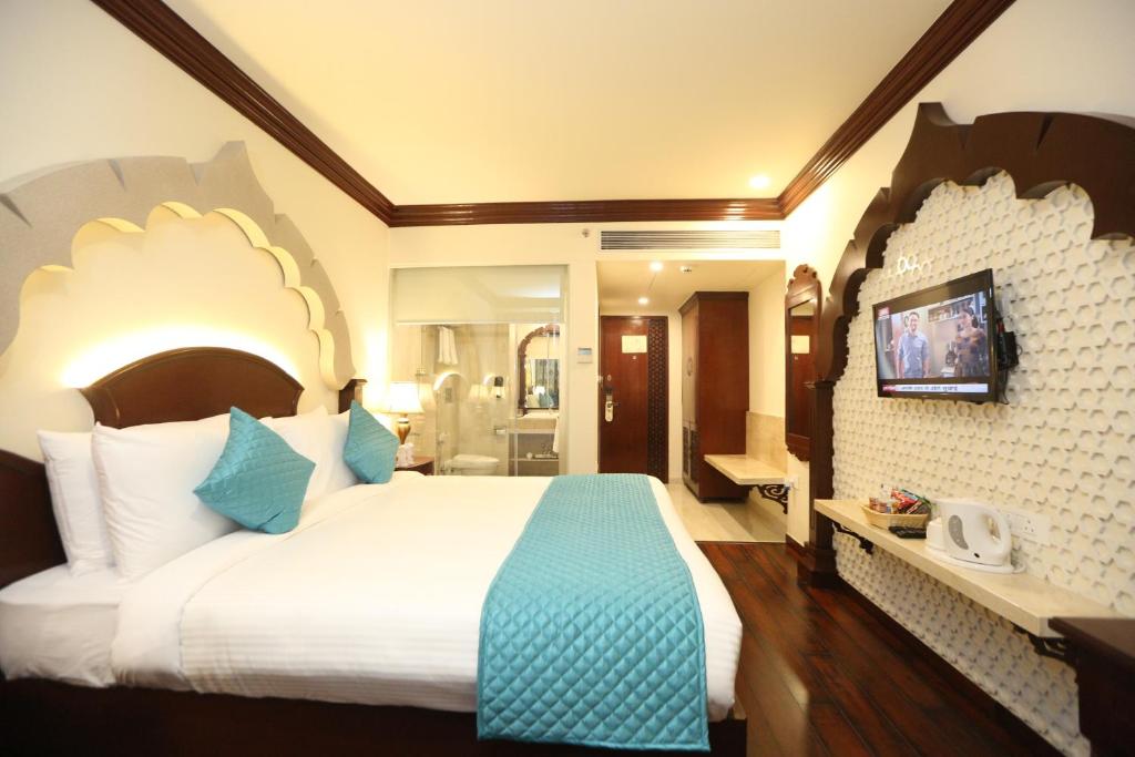 a hotel room with a large bed and a bathroom at Comfort Inn Sapphire - A Inde Hotel in Jaipur