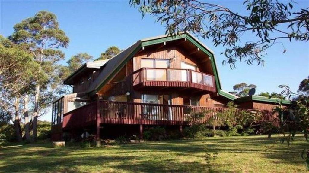 Casa grande con balcón en un campo de césped en Sublime Cedar Lodge Leura, en Leura