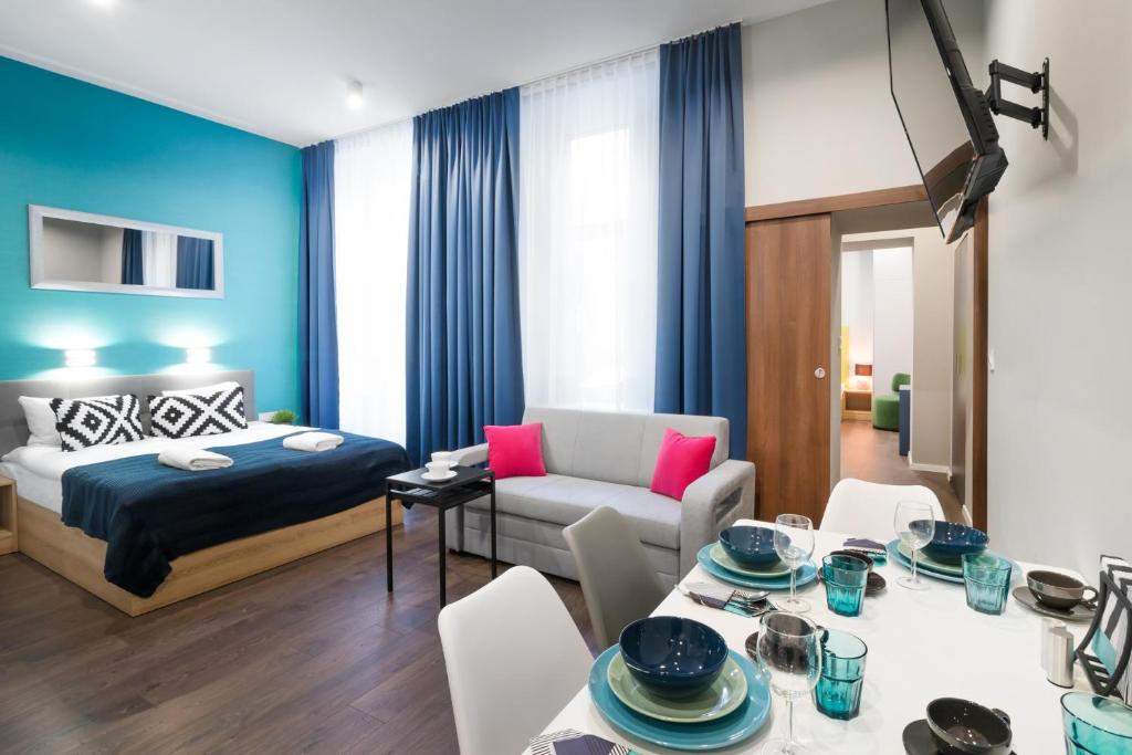 クラクフにあるKings City - Sławkowska Apartmentsのベッドとダイニングルームが備わるホテルルームです。