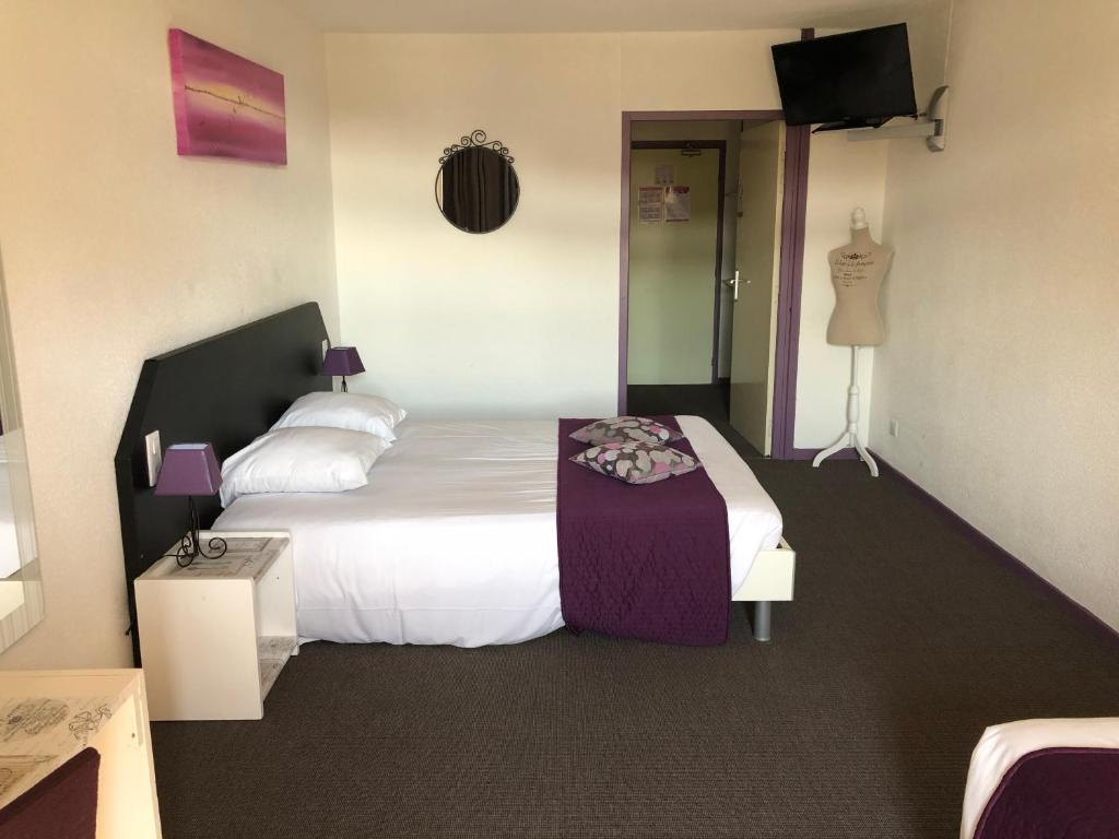 a hotel room with a bed and a television at Le Clos des Bruyères in Vallon-Pont-dʼArc