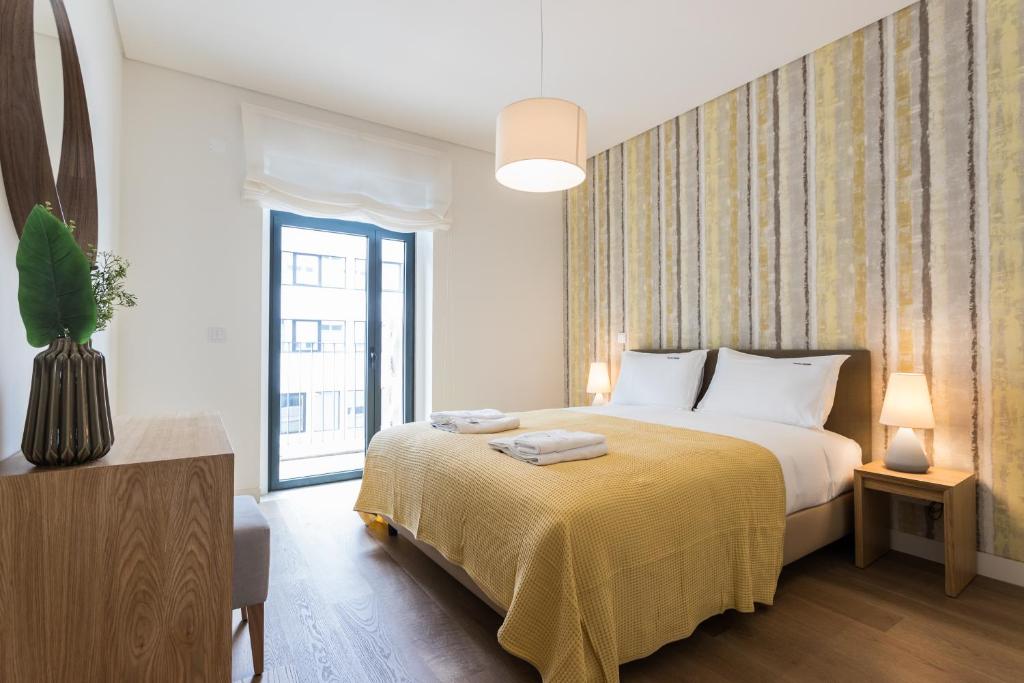 a bedroom with a bed with a yellow blanket at FLH Avenida da Liberdade Fantastic Flat in Lisbon