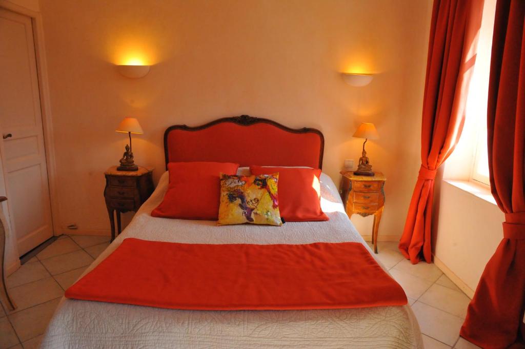 a bedroom with a bed with red sheets and pillows at Villa Valflor chambres d'hôtes et appartements in Marseille