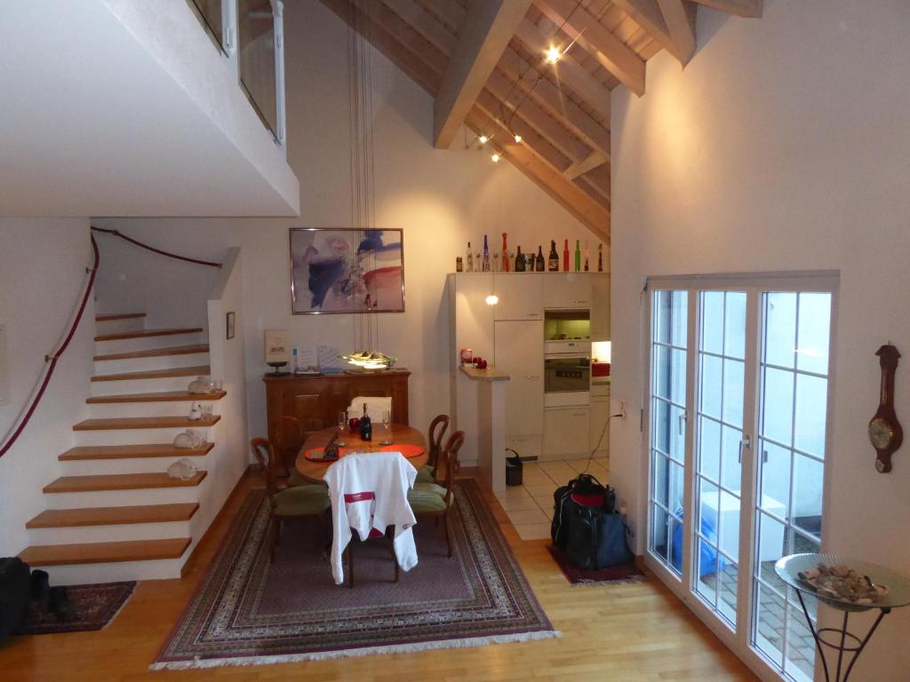 ein Wohnzimmer mit einem Tisch und einer Treppe in der Unterkunft Haus Gaschür in Bad Ragaz