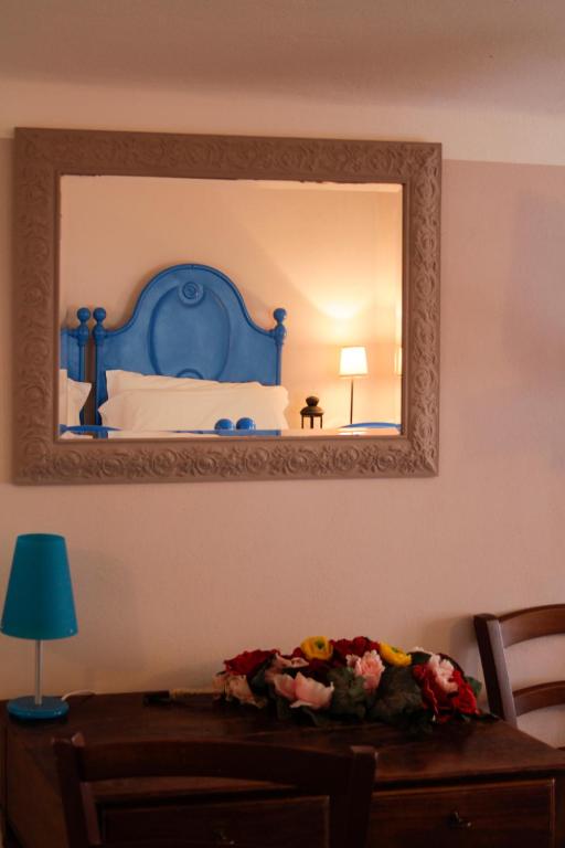 Un dormitorio con una cama azul y un espejo. en La Locanda Del Podestà Cinque terre, en La Spezia