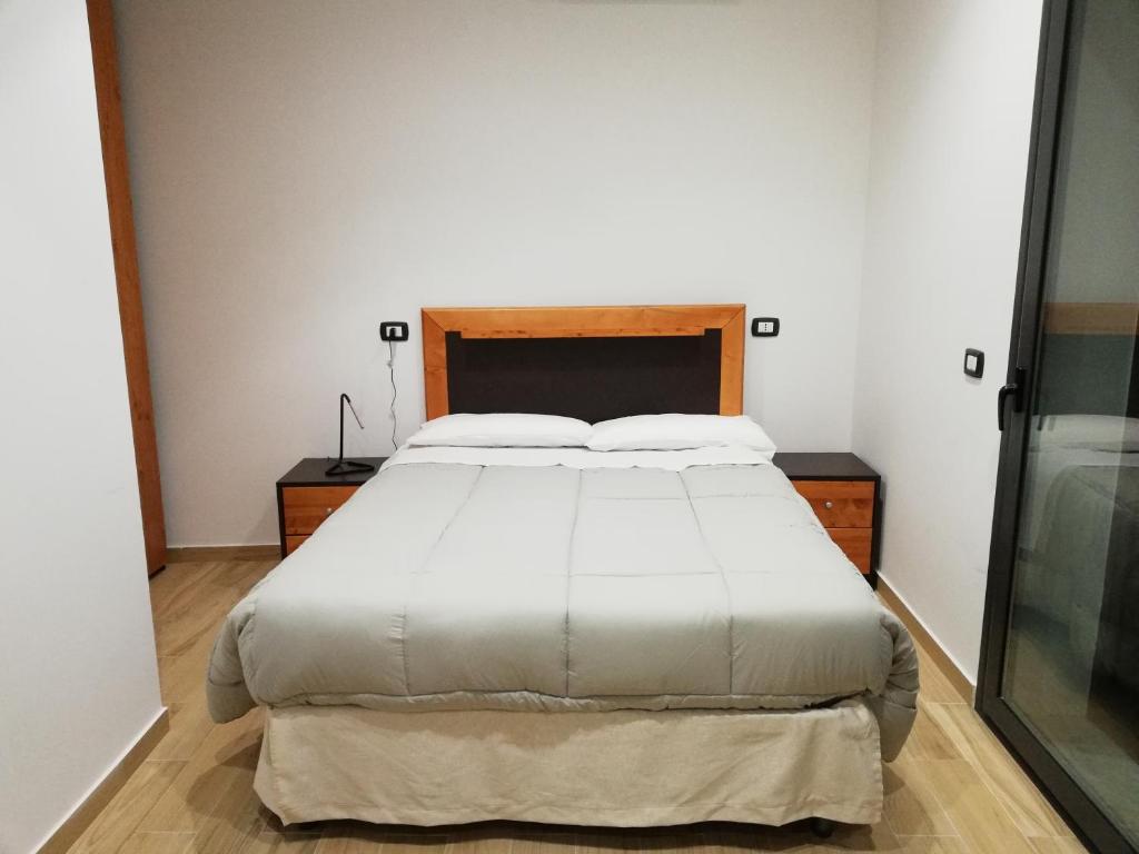 sypialnia z dużym łóżkiem z białą pościelą w obiekcie B&B Controtempo w mieście Reggio di Calabria