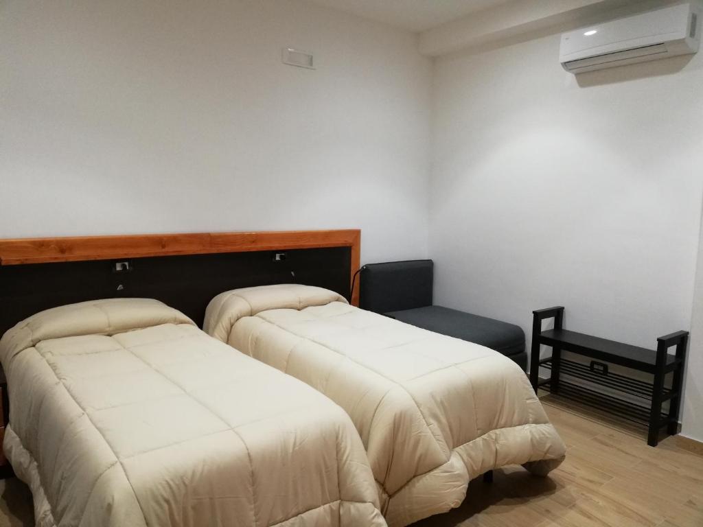 pokój z dwoma łóżkami i ławką w środku w obiekcie B&B Controtempo w mieście Reggio di Calabria
