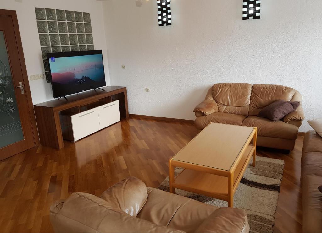 ein Wohnzimmer mit 2 Sofas und einem Flachbild-TV in der Unterkunft Luxe Apartment in Ohrid