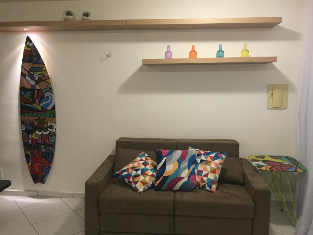 sala de estar con sofá y tabla de surf en Flat no La Piazzetta - Ap. 14 Térreo, en Pipa