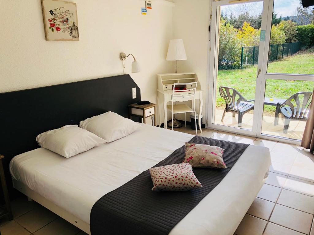 a bedroom with a bed with two pillows on it at Le Clos des Bruyères in Vallon-Pont-dʼArc