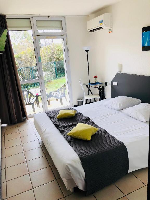 a bedroom with a large bed with two pillows on it at Le Clos des Bruyères in Vallon-Pont-dʼArc