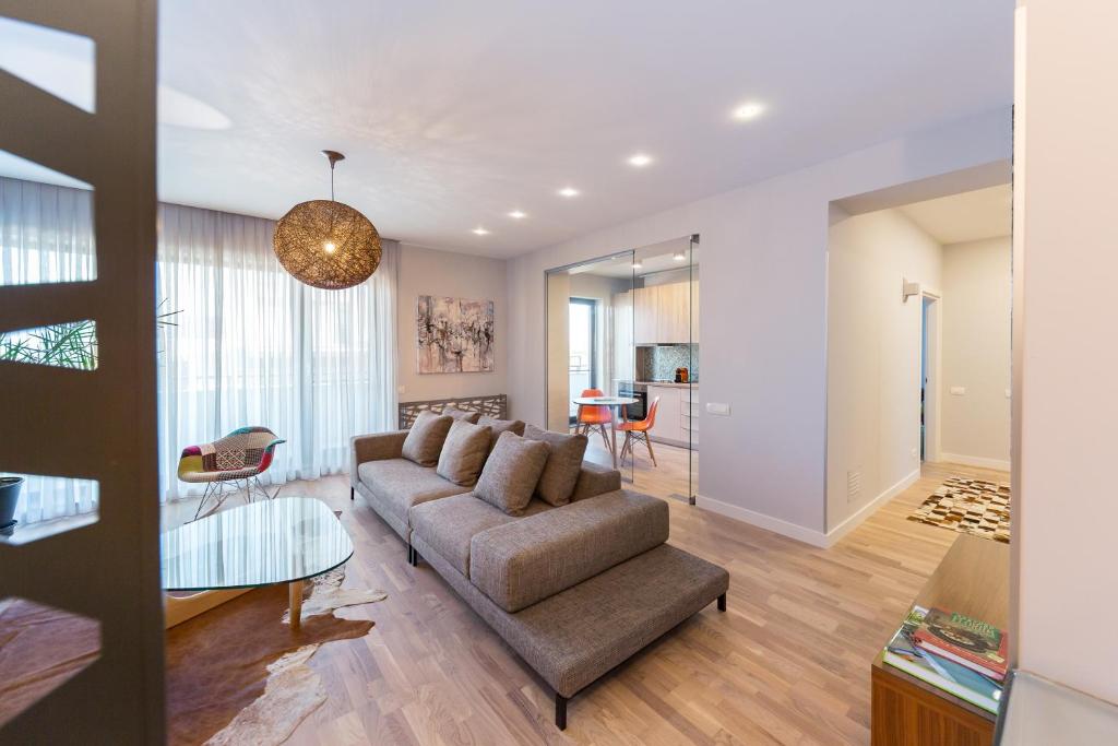 a living room with a couch and a table at The Shades of Grey-Tranquil 4th-Floor Apartment in Bucharest