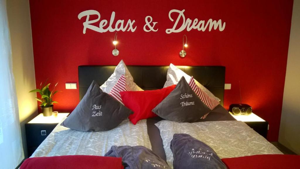 Un dormitorio con una pared roja y una cama con almohadas en Pension Pauly, en Boppard