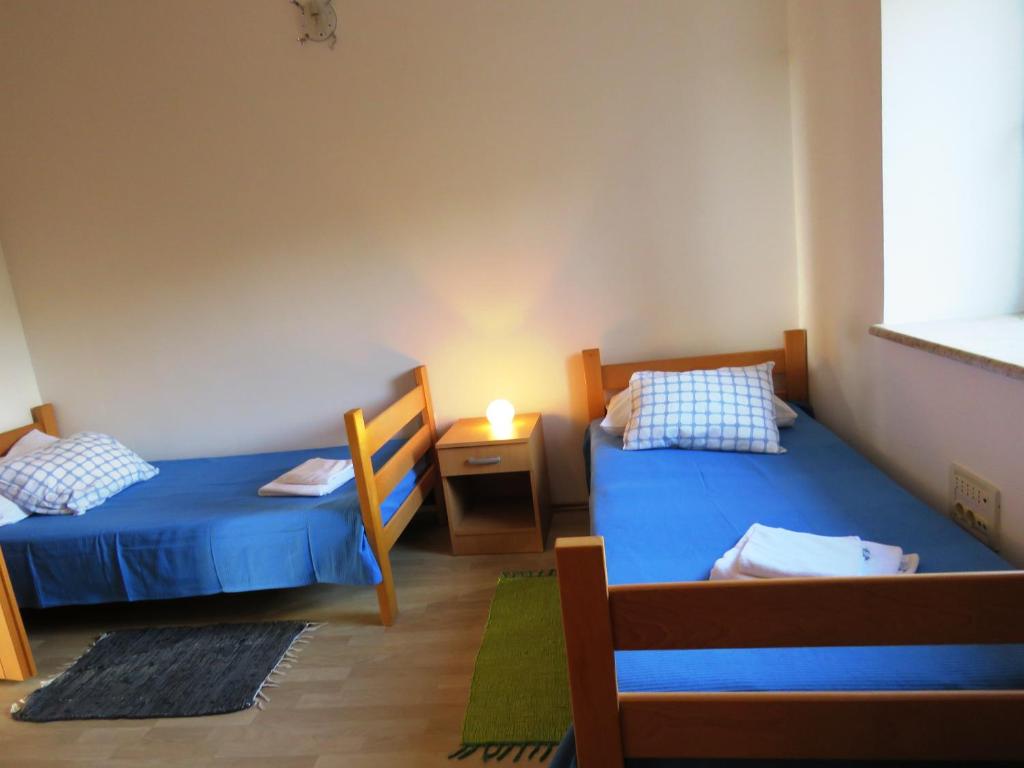 een kamer met 2 bedden en een tafel met een lamp bij Apartments Dolić Novalja in Novalja