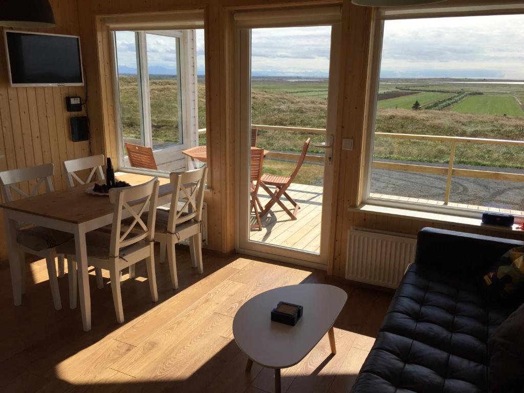 ein Wohnzimmer mit einem Sofa und einem Tisch sowie einem Balkon in der Unterkunft Sodulsholt Cottages in Sodulsholt