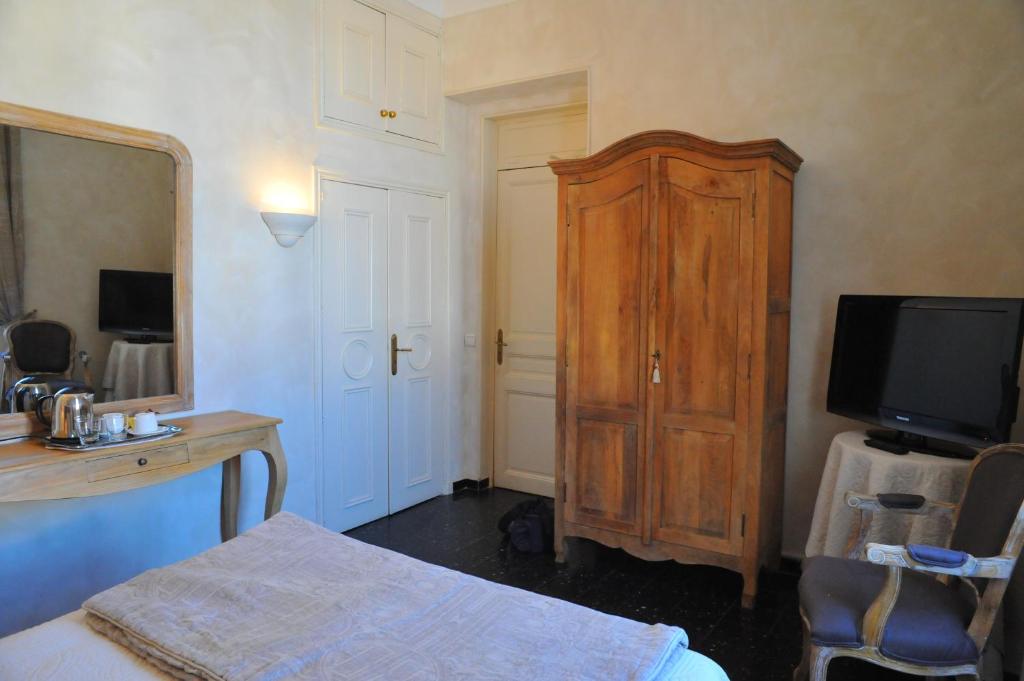 a bedroom with a wooden cabinet and a television at Villa Valflor chambres d'hôtes et appartements in Marseille