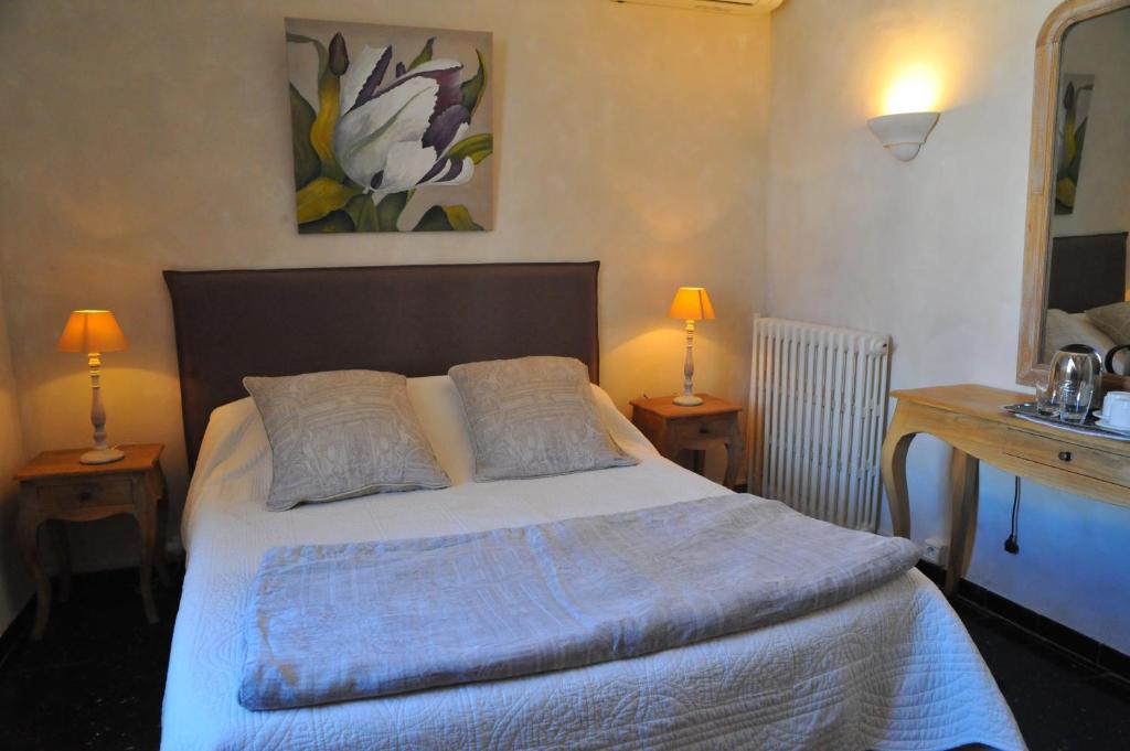 a bedroom with a bed with two lamps on two tables at Villa Valflor chambres d'hôtes et appartements in Marseille
