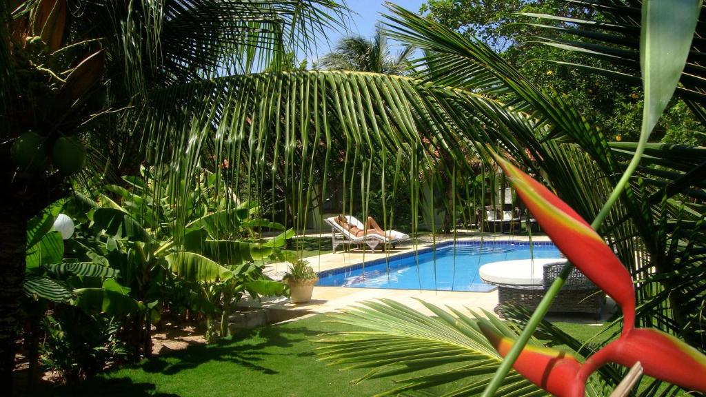 une piscine avec deux chaises longues dans un jardin dans l'établissement Refugios Parajuru - Casa Verde, à Parajuru