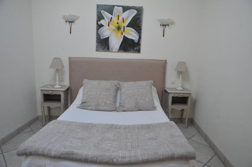 a bedroom with a bed with two nightstands and two lamps at Villa Valflor chambres d'hôtes et appartements in Marseille