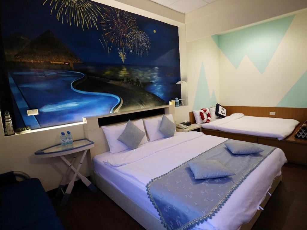 a bedroom with two beds and a painting on the wall at Sabai B&amp;B 澎湖船家寶民宿 in Huxi