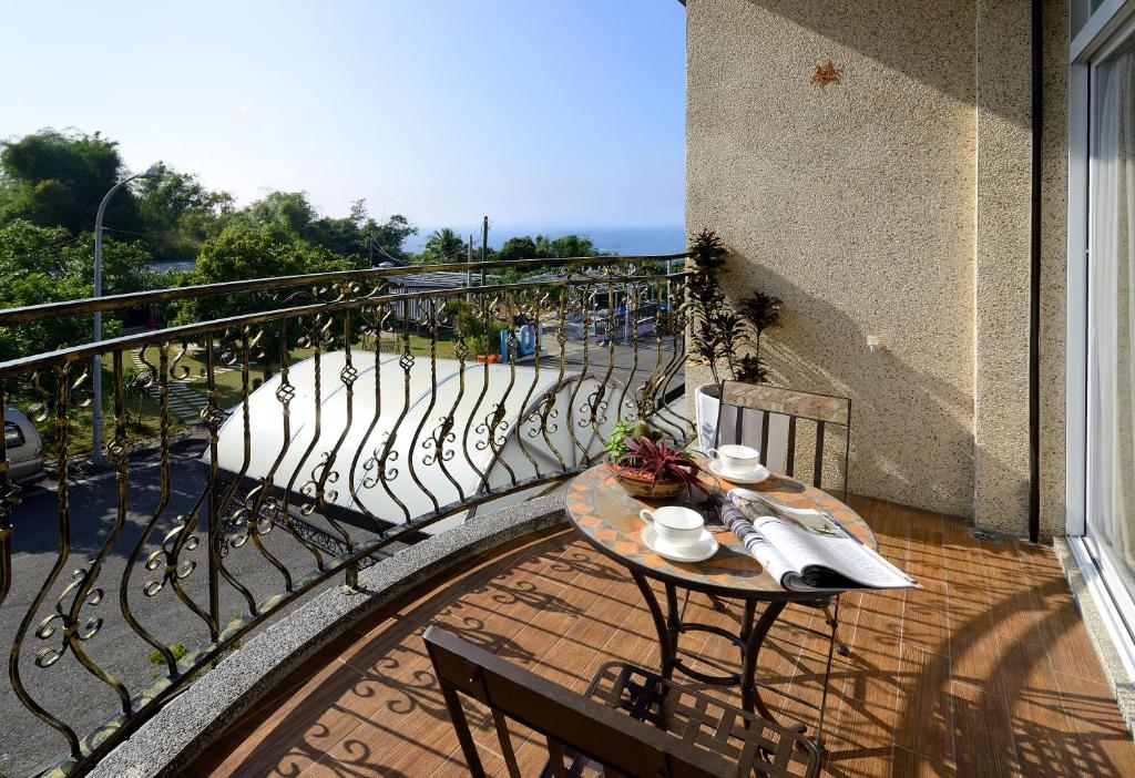 a balcony with a table and chairs on a balcony at 月牙灣 in Xiaoliuqiu