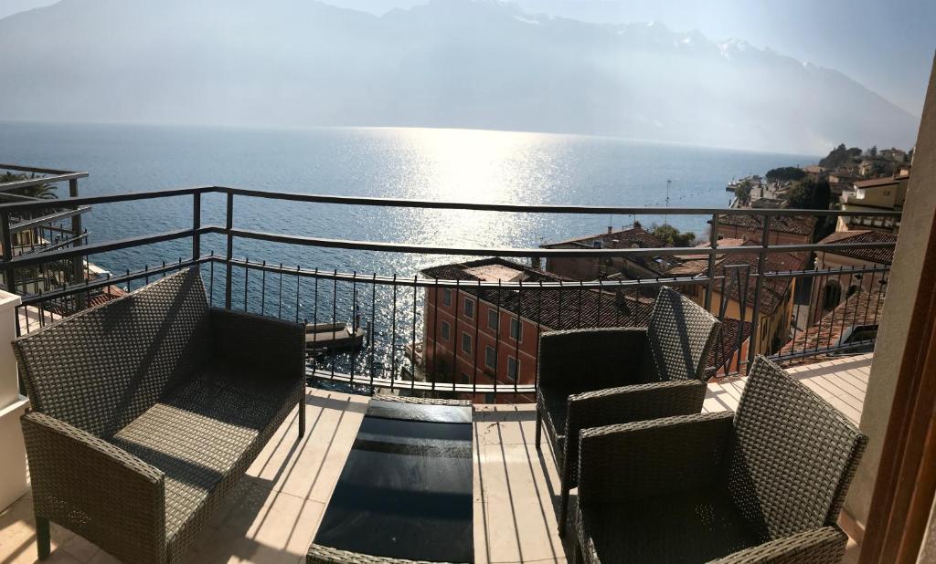 a balcony with chairs and the ocean in the background at Villa Castello in Limone sul Garda