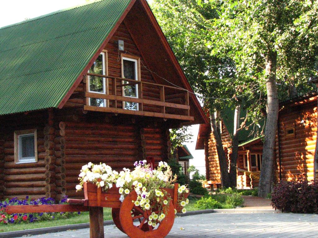a log cabin with a planter of flowers in front of it at Chastnaya Dacha in Volgograd