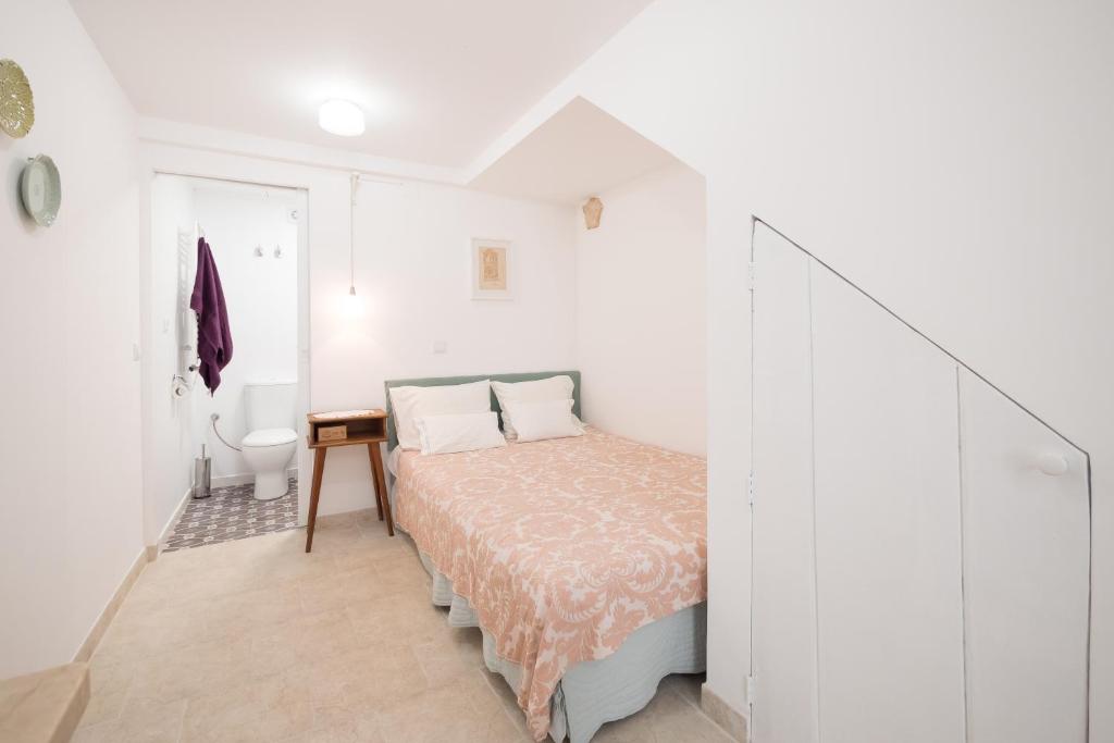 ein kleines Schlafzimmer mit einem Bett und einem Badezimmer in der Unterkunft Little studio for two-Alfama in Lissabon