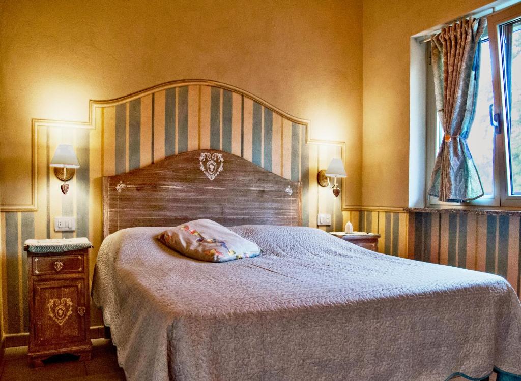 una camera con un grande letto con testiera in legno di B&B Il Rovere a Gattico