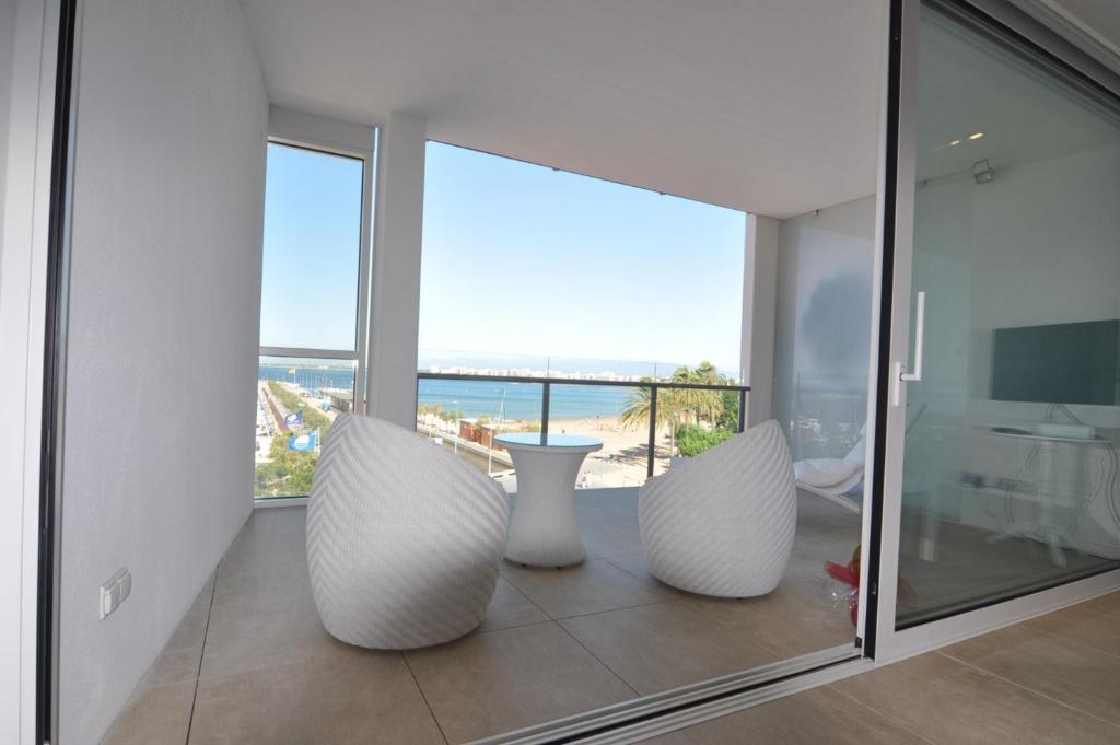 Habitación con 3 grandes jarrones blancos en un balcón. en RNET - Cap Vespre en Rosas