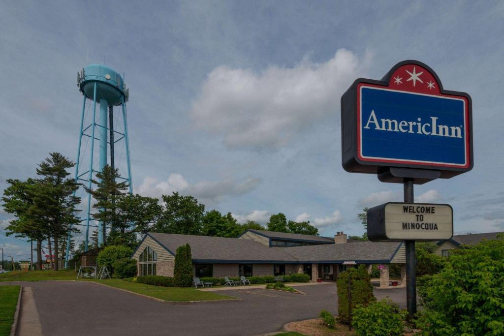 a sign for an american inn with a water tower at AmericInn by Wyndham Minocqua in Minocqua
