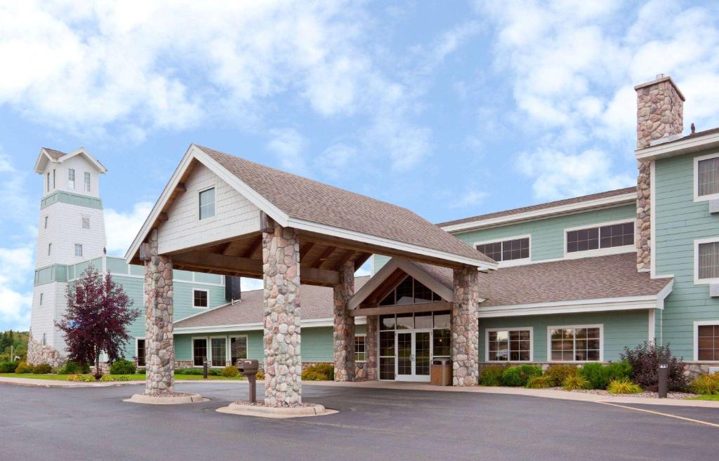 a view of the front of a hospital with a building at AmericInn by Wyndham Wetmore Munising in Wetmore