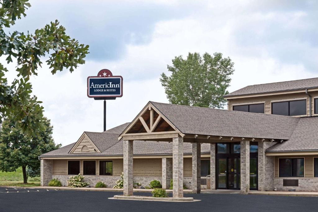 una señal para una posada americana frente a un edificio en AmericInn by Wyndham Tomah, en Tomah