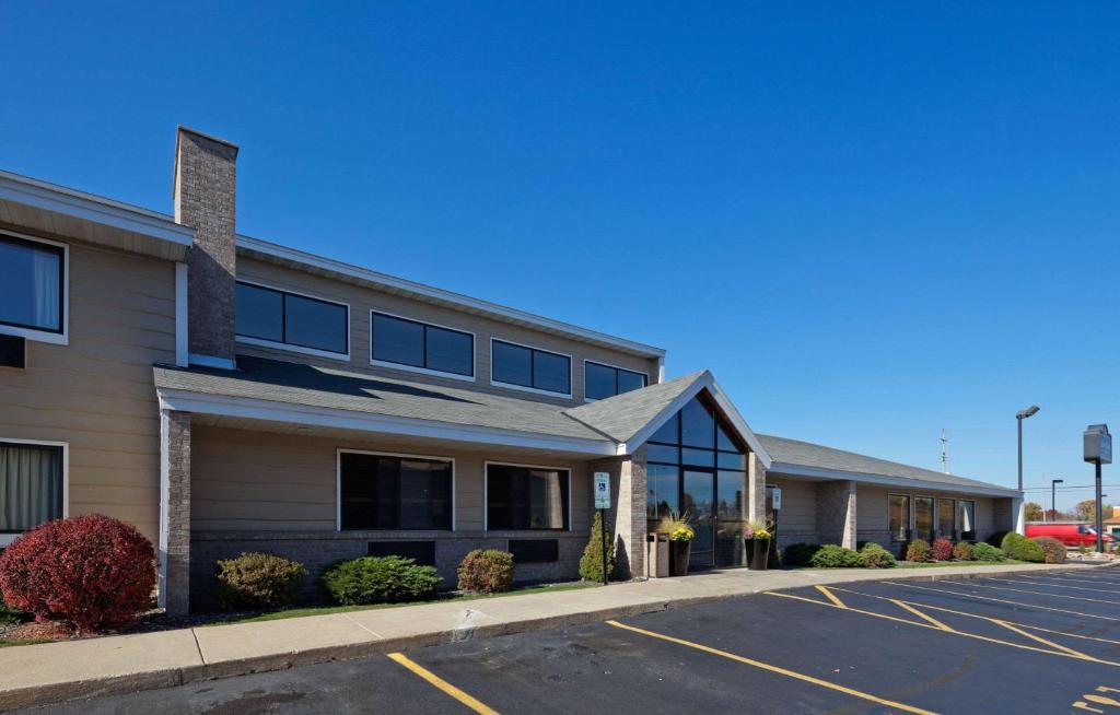 an empty parking lot in front of a building at AmericInn by Wyndham Hartford WI in Hartford