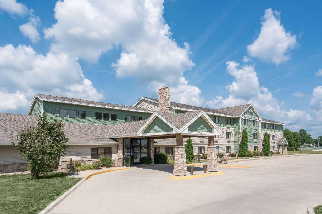 ein großes Haus mit einer Einfahrt davor in der Unterkunft AmericInn by Wyndham Fort Dodge in Fort Dodge