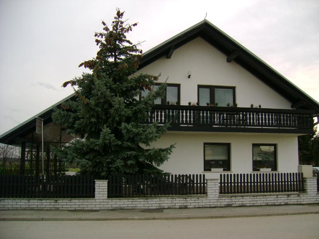 dom z drzewem przed nim w obiekcie Guest Accomodation Škerlak w mieście Moravske Toplice