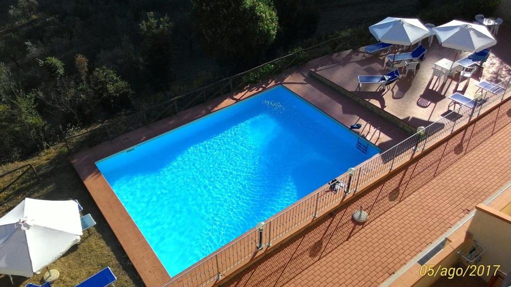 - une vue sur la grande piscine bordée de parasols dans l'établissement La Casa dei Sogni, à Monteverdi Marittimo