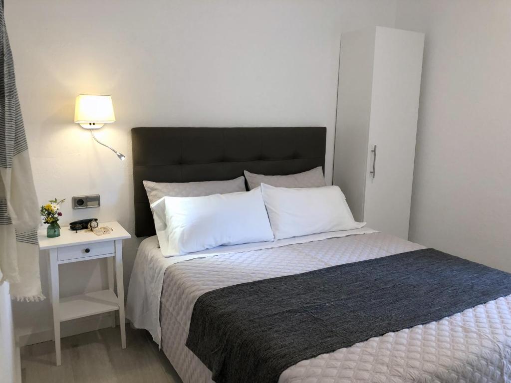 um quarto com uma cama grande e uma mesa de cabeceira em Apartaments La Palmera, Terrace & Pool em Sant Martí d’Empúries