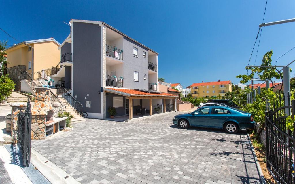 a car parked in a parking lot next to a building at Apartments Bernardeta 1 in Baška