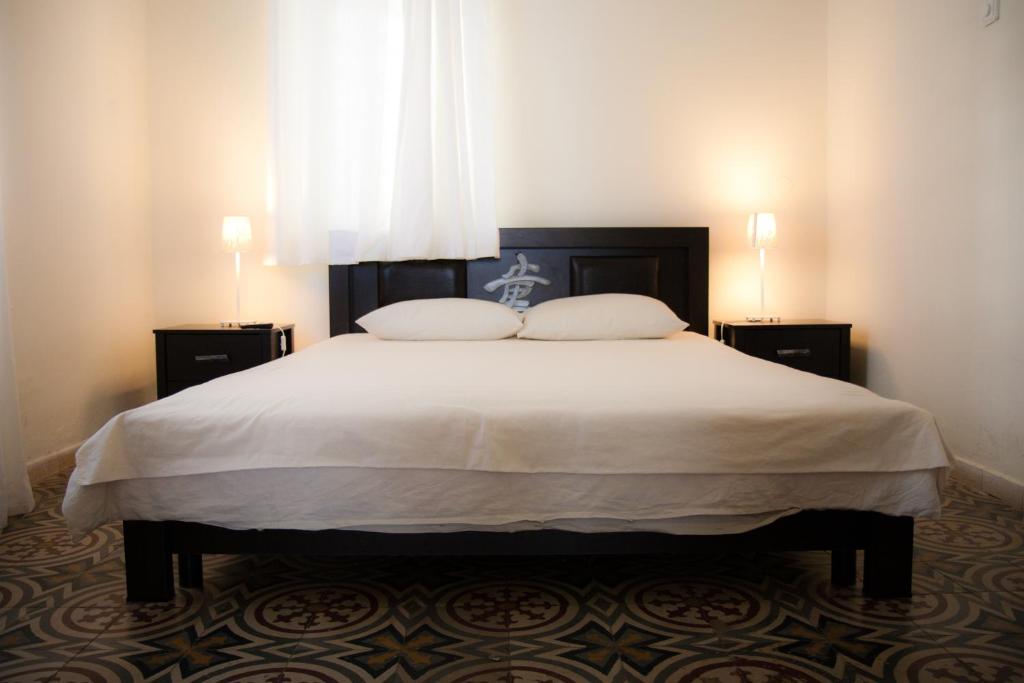 a bedroom with a large white bed with two night stands at Neve Tzedek Original Style Apartments in Tel Aviv