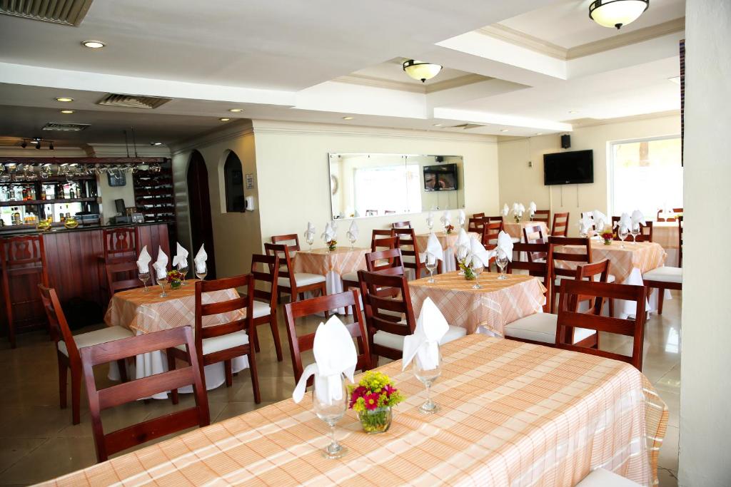 Hotel Los Jardines في سانتياغو دي لوس كاباليروس: مطعم فيه طاولات وكراسي في الغرفة